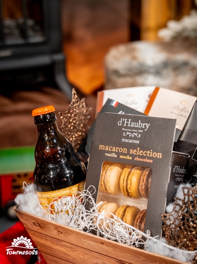 Panier garni avec macarons, bière artisanale et décor festif.